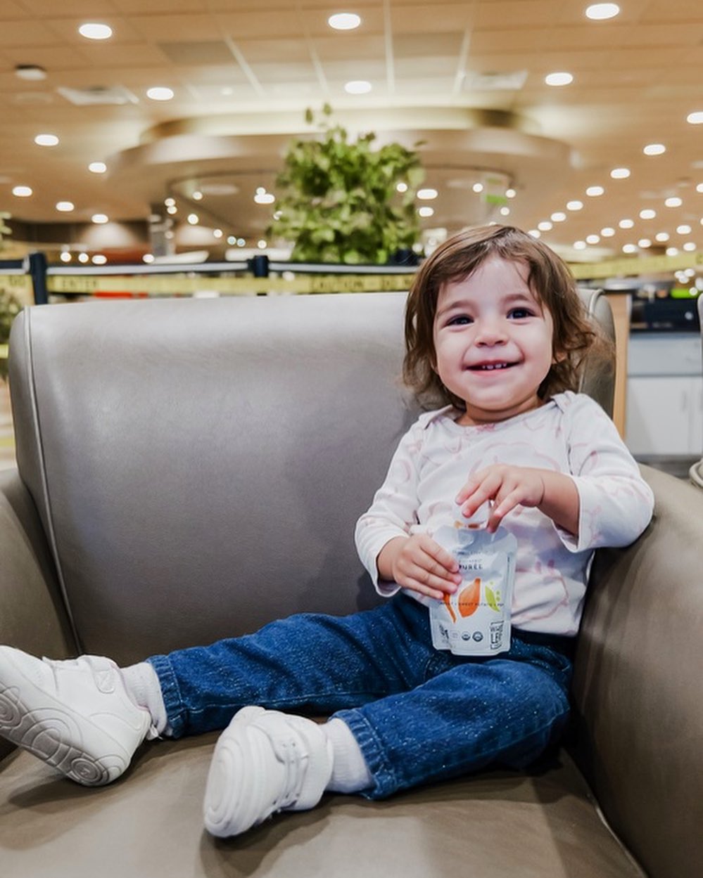 Toddler eating carrot sweet potato pea baby food pouch