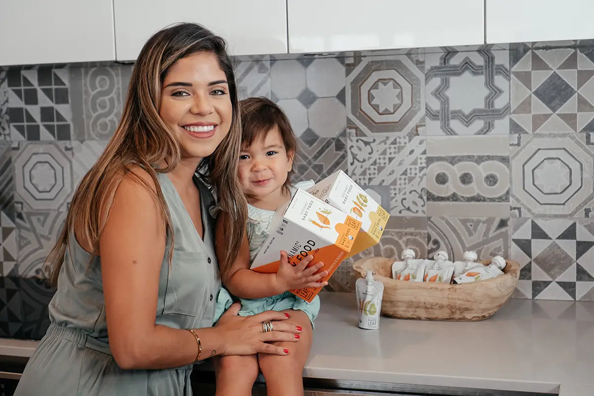 mom and baby holding White Leaf baby food subscription pouches for delivery